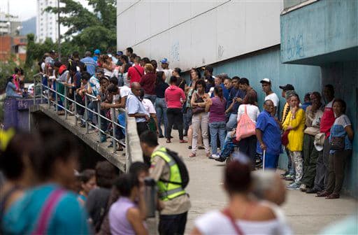 Un grupo de personas espera en el exterior de un supermercado para comprar comida subvencionada por el gobierno en Caracas, la capital. A medida que la producción nacional se frena, el estado adquiere el rol de importar casi toda la comida que llega al país.