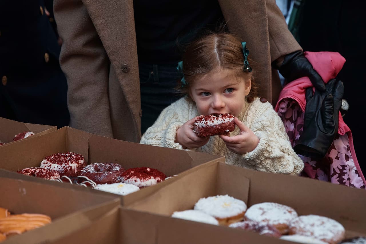 Una niña disfruta de una dona en medio del desfile del Día de San Patricio.