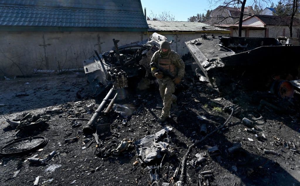 En esta foto, un soldado ucraniano evalúa cómo quedó un vehículo blindado en Irpin. Según un recuento de 
<i>The New York Times</i>, desde que comenzó la invasión al menos 67 pueblos y ciudades han sido atacados, algunos durante varios días, con bombardeos, ataques aéreos y otros proyectiles.