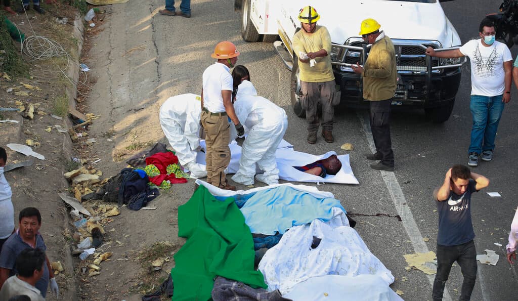 Bodies in bodybags are placed on the side of the road after an accident in Tuxtla Gutierrez, Chiapas state, Mexico, Dec. 9, 2021. Mexican authorities say at least 49 people were killed and dozens more injured when a cargo truck carrying Central American migrants rolled over on a highway in southern Mexico. (AP Photo )