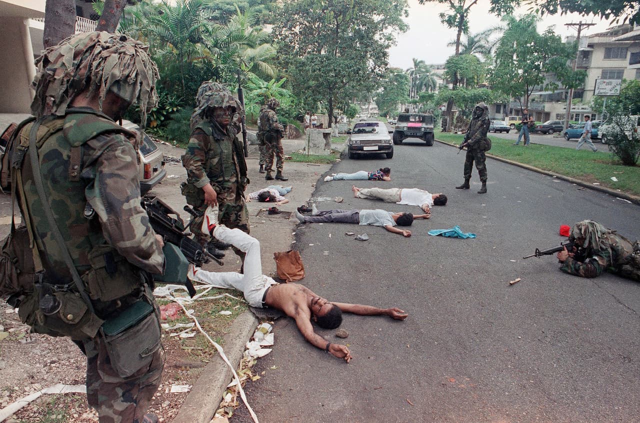 En esta foto de archivo del 26 de diciembre de 1989, soldados estadounidenses apuntan mientras buscan sospechosos detenidos fuera de la casa de un socio comercial del general Manuel Noriega en Ciudad de Panamá.