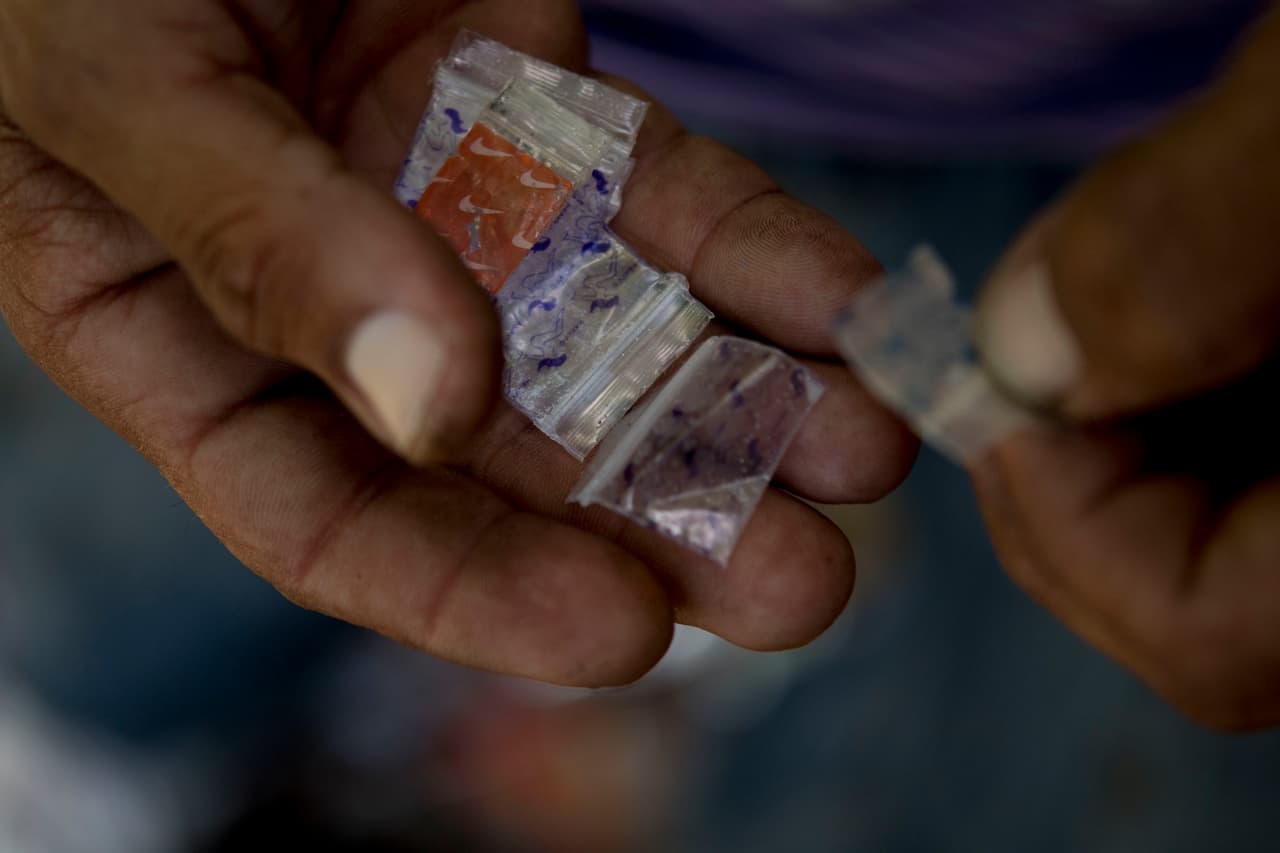 Un drogadicto entrega bolsitas de heroína vacías a un miembro de un programa de intercambio de agujas para que las examine en busca de fentanilo.