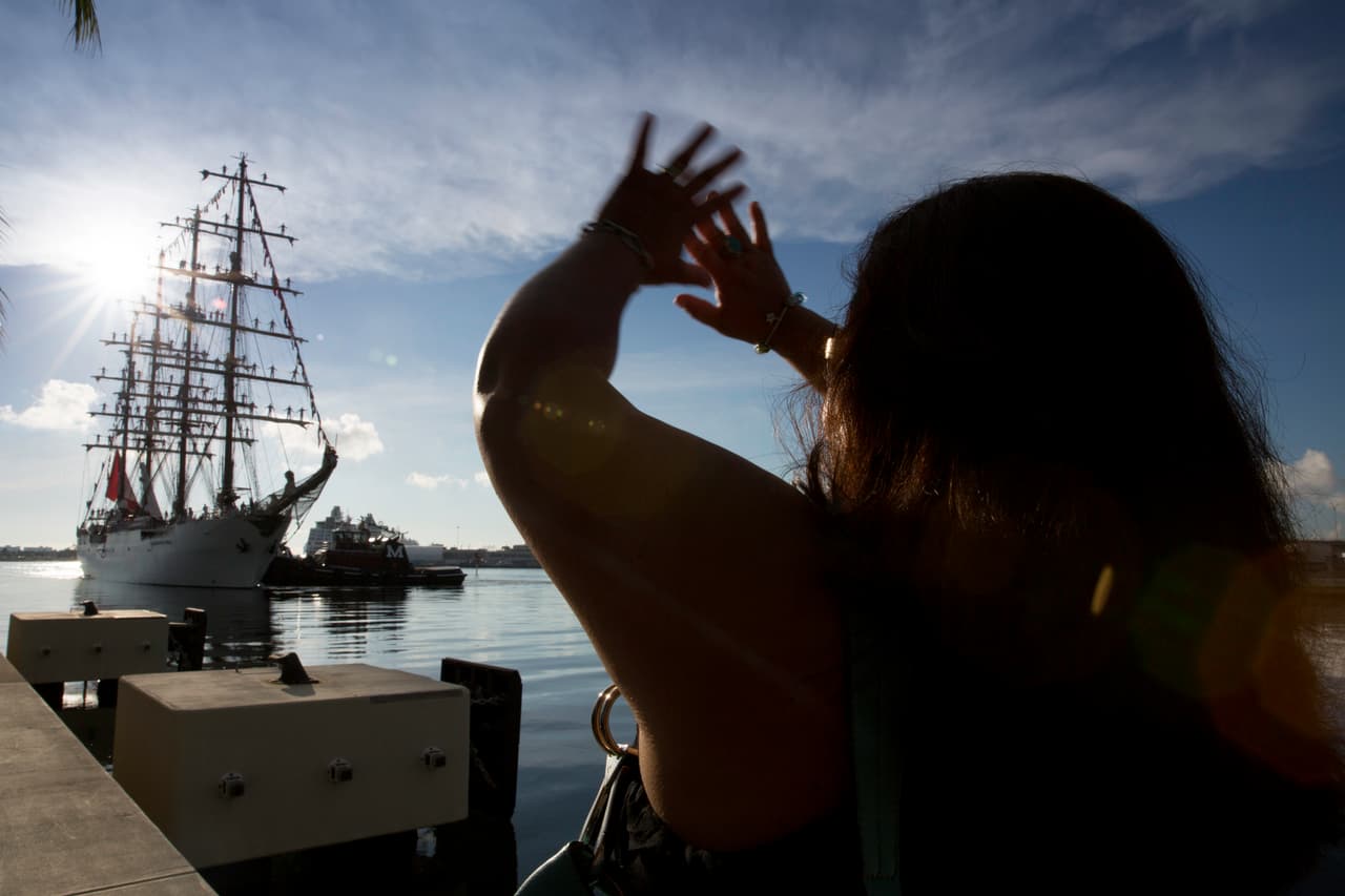 Lizbeth voló de Connecticut a Miami para poder ver a su hijo. Con lágrimas en sus ojos, empieza a agitar sus brazos en el aire cuando ve que el buque donde viene Manlio se acerca al muelle del Museum Park.