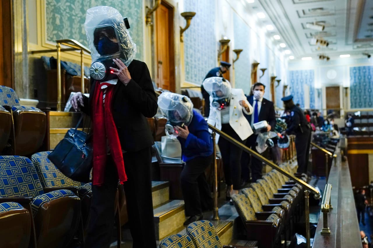 <b>Una fila de congresistas con máscaras antigás</b>
<br>
<br>Durante la dramática evacuación dentro del Capitolio, la policía repartió máscaras para que los presentes se protegieran de los gases.
<br>