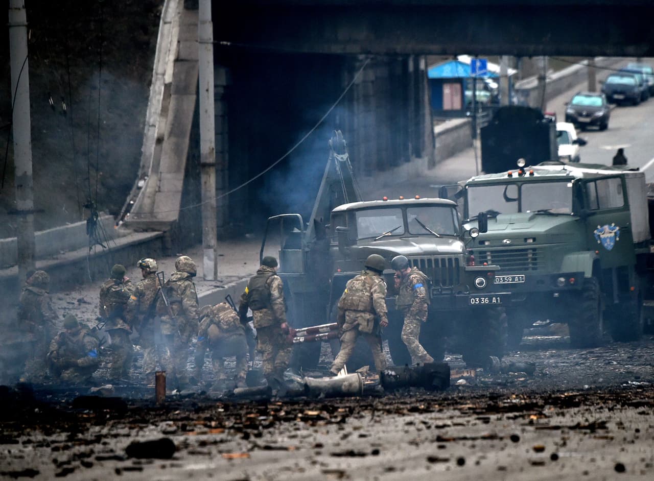 Miembros del servicio ucraniano recogen proyectiles sin explotar tras un combate con un grupo de asalto ruso en la capital ucraniana de Kiev en la mañana del 26 de febrero de 2022, según el personal del servicio ucraniano en el lugar de los hechos.