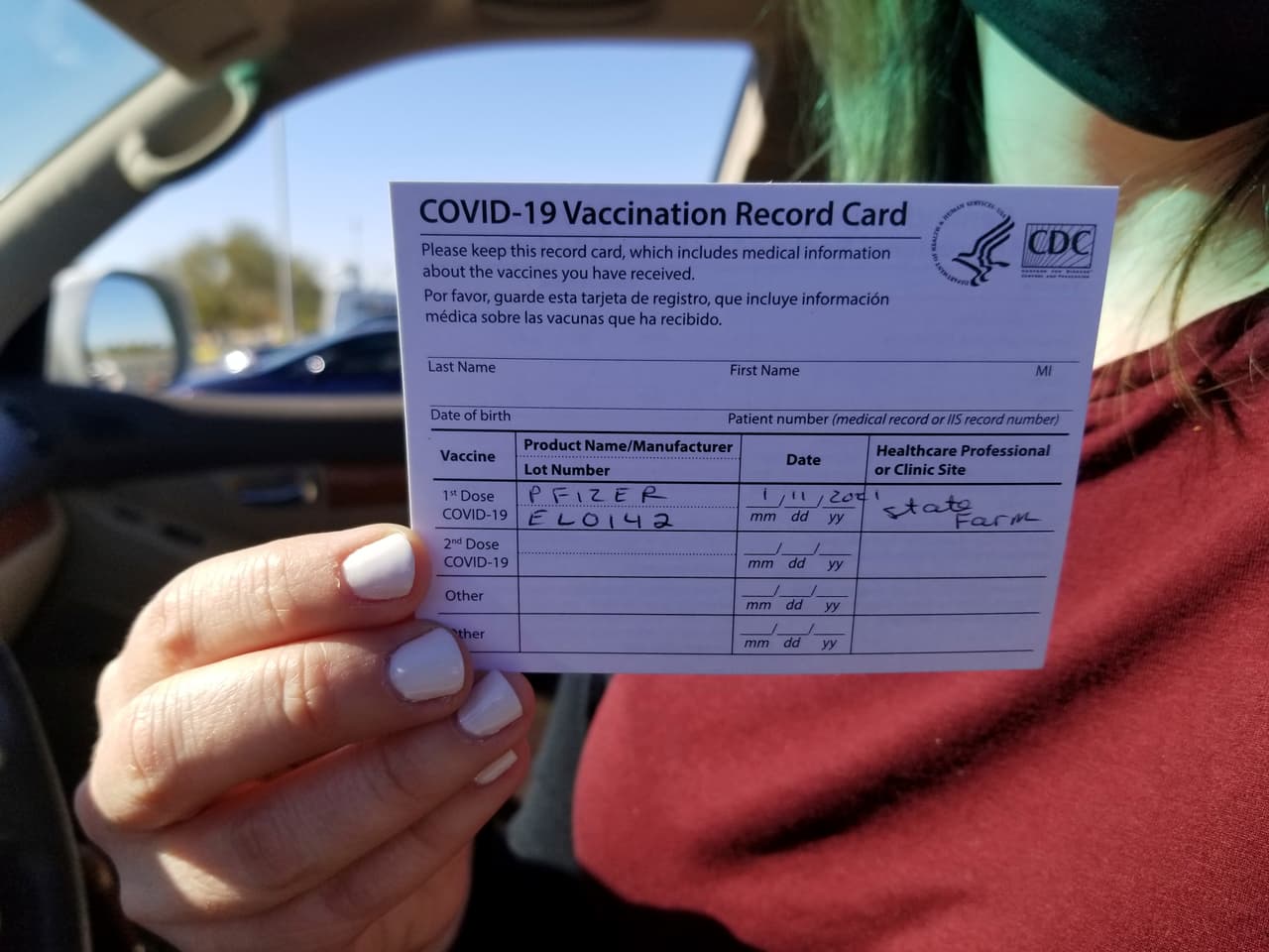 Emily Alexander, de 37 años, muestra su tarjeta de vacunación poco después de recibir la vacuna en el estacionamiento del 
<b>State Farm Stadium en Glendale, Arizona</b>, el lunes 11 de enero de 2021. El estadio de los Arizona Cardinals abrió como sitio de vacunación en una operación 24-7.