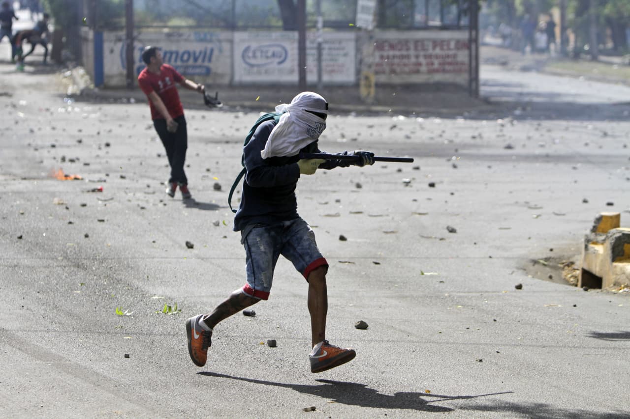Ortega calificó a los manifestantes de “minorías” y los acusó de estar siendo manipulados por quienes buscan desestabilizar, reproduciendo la retórica que Murillo ha venido ofreciendo desde que estalló la crisis. En la fotografía, un estudiante se prepara para disparar con un arma casera a la policía antidisturbios.