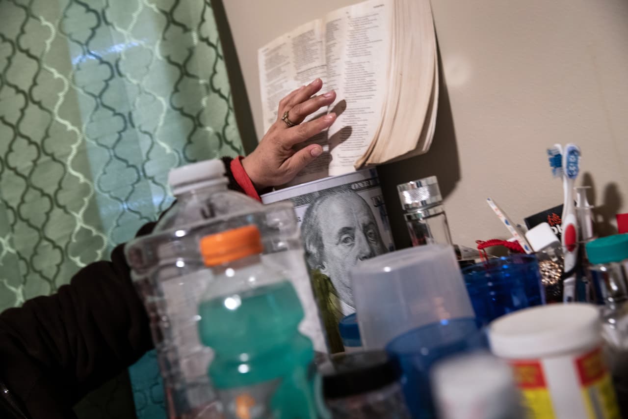Una inmigrante hondureña indocumentada en cuarentena, cuando colocó su biblia junto al recipiente donde guarda sus ahorros. Para algunos no está claro si podrán acceder a los beneficios económicos que dará el gobierno a propósito de la pandemia. Según las autoridades, los contribuyentes con un ingreso bruto de $75,000 (individuos) y de $150,000 (parejas casadas) que hayan declarado impuestos conjuntamente recibirán el incentivo. 
<a href="https://www.univision.com/noticias/dinero/el-irs-brinda-nueva-informacion-sobre-como-obtener-la-ayuda-financiera-por-la-crisis-del-coronavirus">Vea aquí la información del IRS sobre cómo obtener la ayuda financiera por la crisis del coronavirus </a>