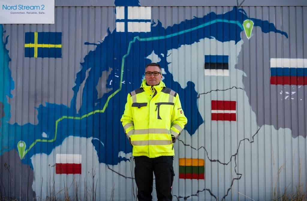 Mayor of the German coastal resort town of Lubmin, northeastern Germany, Axel Vogt poses in front of an information point container decorated with a map showing the Nord Stream 2 gas pipeline, which was expected to deliver Russian gas to European households, in Lubmin's industrial park, on March 1, 2022.