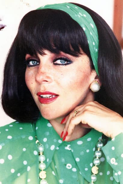 Por ejemplo, en este look noventero irradia mucha elegancia con sus perlas e indumentaria que combina a la perfección con el color de sus ojos. Y para rematar, sus uñas de color rojo (un tono de esmalte muy clásico que contrasta muy bien con cualquier estilo).