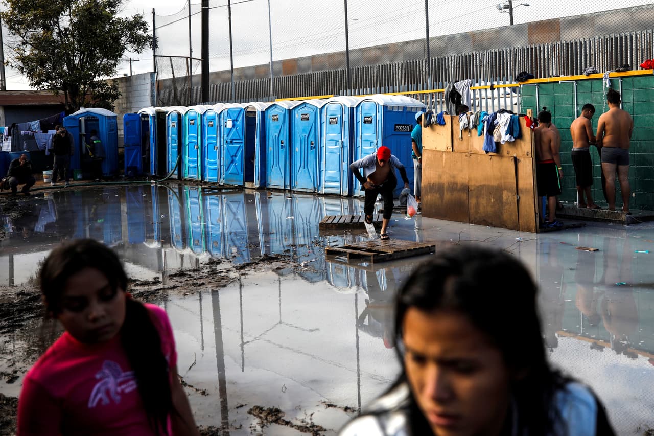 Los sanitarios portátiles desbordados y un enorme charco de agua sucia que crece cada vez que alguien se ducha refleja las condiciones en las que se encuentran los más de 6,000 migrantes que están albergados en La Unidad Deportiva Benito Juárez, al norte de Tijuana.