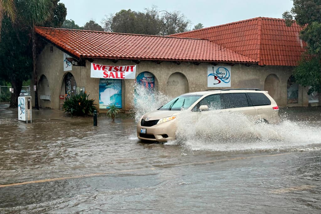 Un vehículo avanza sobre el agua en una calle inundada en Ventura, California, el domingo 4 de febrero de 2024. El sur de California corría riesgo de sufrir inundaciones sustanciales a partir del domingo por la noche debido a lo lento que se movía el sistema, dijo Ryan Kittell, meteorólogo de la oficina del servicio meteorológico del área de Los Ángeles. (Foto AP/Eugene García)