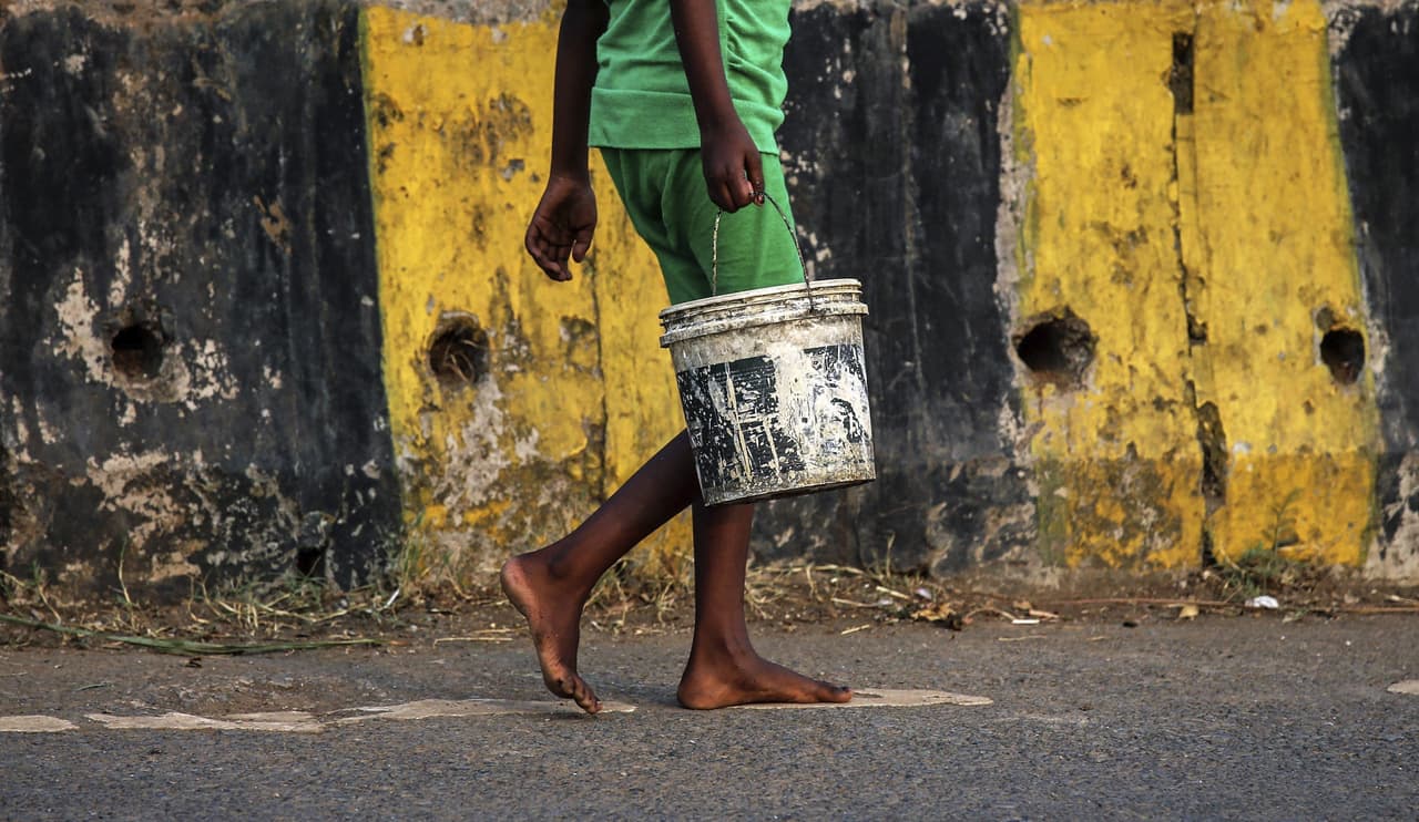 Una niña sostiene un cubo mientras camina hacia las letrinas a las afueras de Bombay (India) .