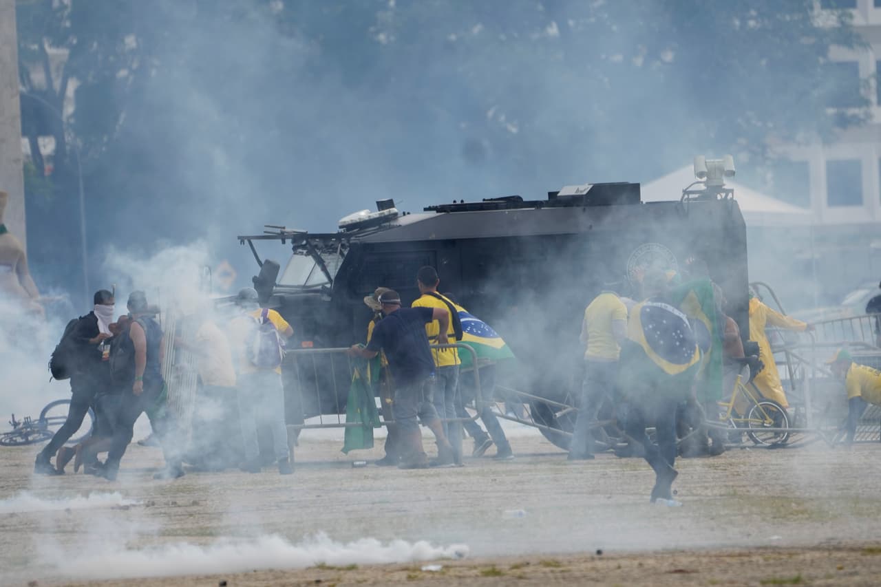 Simpatizantes de Bolsonaro atacan uno de los vehículos de la policía que llegó al lugar para restablecer el orden.