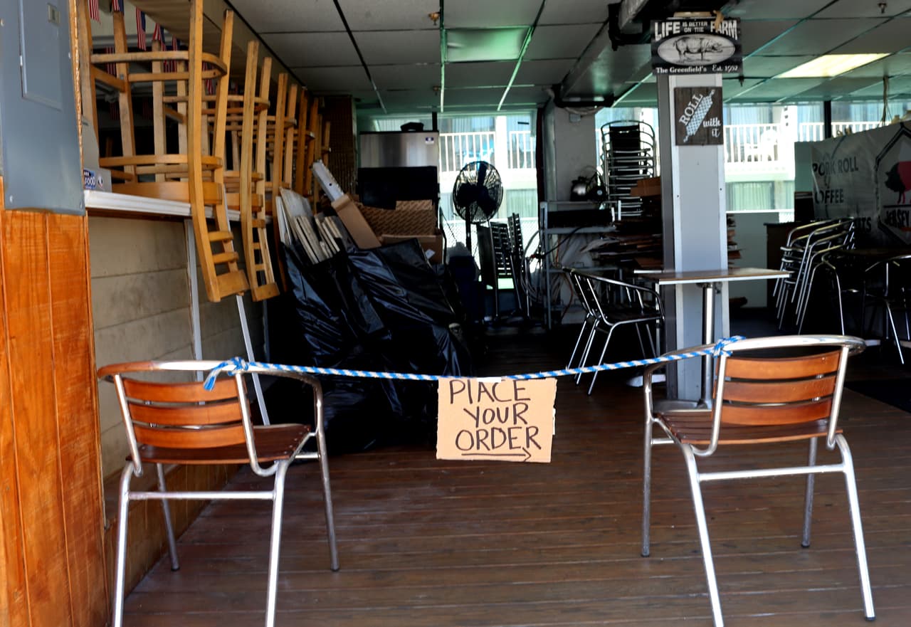 Una tienda de sandwiches anuncia que está abierta para pedidos de comida para llevar en el paseo marítimo de Seaside Heights.