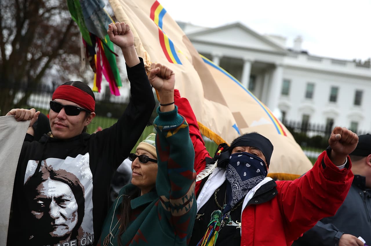 Un manifestante de pie delante de la Casa Blanca durante una manifestación contra el oleoducto Dakota Access el 10 de marzo de 2017. En la primera semana de su presidencia, Donald Trump firmó órdenes ejecutivas para reactivar el proyecto Dakota Access, junto con un segundo oleoducto puesto en suspenso por la administración Obama, Keystone XL.
