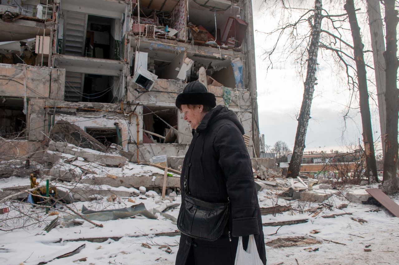 Una mujer camina frente a un edificio alcanzado por las bombas en Járkov, la segunda ciudad más grande de Ucrania, situada al noreste del país. El presidente ucraniano, 
<a href="https://www.univision.com/noticias/mundo/volodimir-zelensky-presidente-ucrania-perfil">Volodymyr Zelensky</a>, advirtió este domingo de que era "cuestión de tiempo" para que misiles rusos alcanzaran países de la OTAN. “Si no cierran nuestro espacio aéreo, es solo cuestión de tiempo que los misiles rusos caigan en territorio de la OTAN. Sobre los hogares de los ciudadanos de los países de la OTAN”, dijo.
