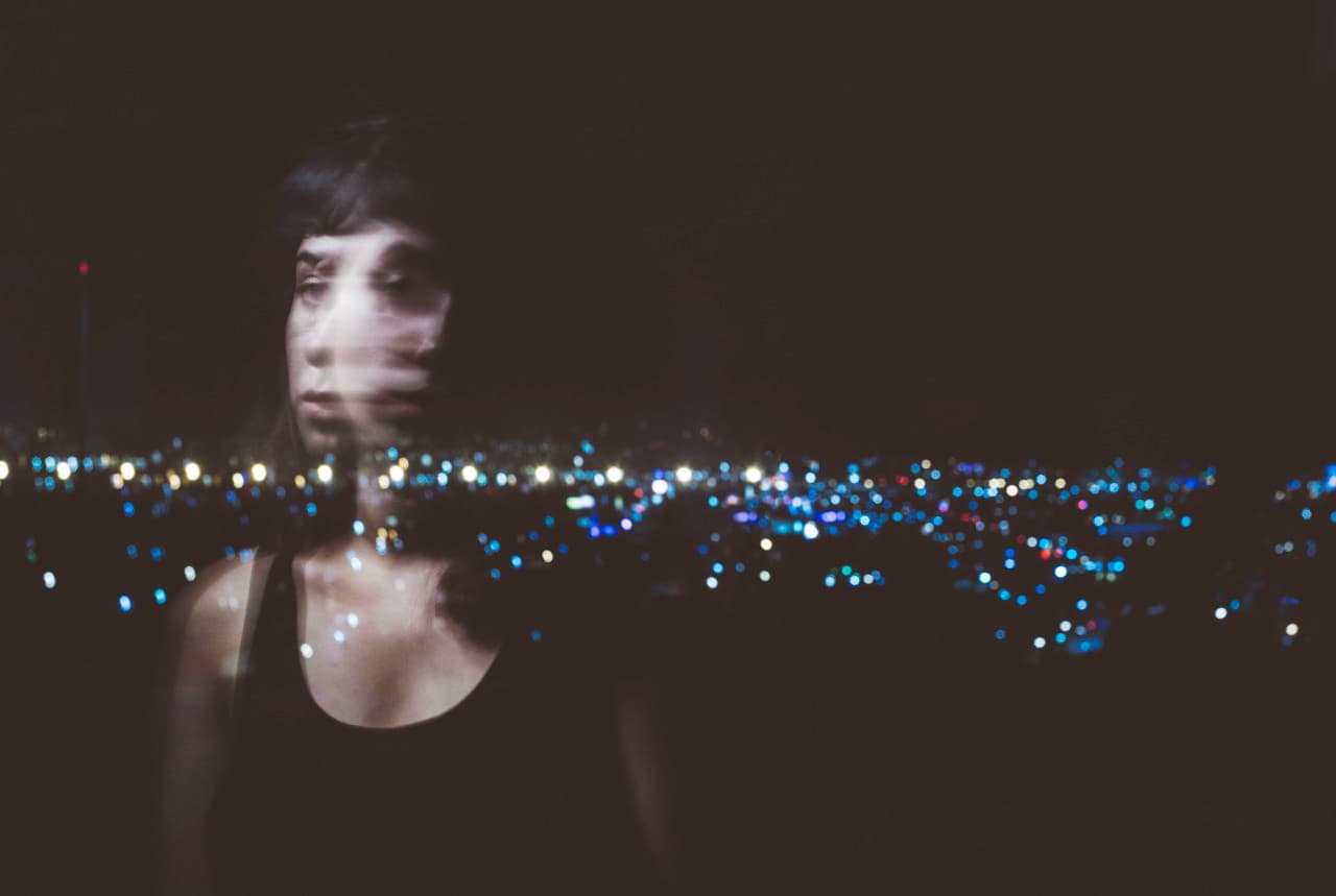 Una joven frente a las luces de la frontera.