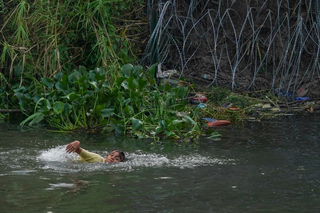 Un joven migrante nada a través del río Grande (Bravo) hacia Estados Unidos desde Matamoros, México. La regla migratoria que comienza a regir a medianoche contempla excepciones para permitir la entrada a EEUU, en los que los solicitantes deben demostrar con pruebas casos de persecución, ser víctimas de crimen o de tráfico humano.
<br>