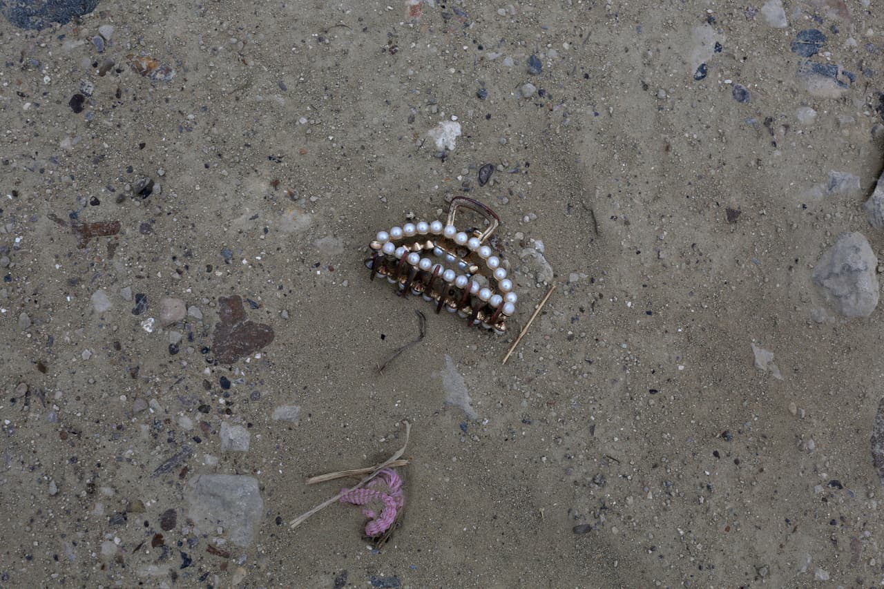 Un broche para el cabello yace entre los objetos que registran el paso de inmigrantes sin papeles en la frontera sur de EEUU, en Roma (Texas). Muchos de ellos, 
<b>desesperados y asustados, salen de las balsas y esperan que los <i>coyotes </i>(traficantes de personas) les den indicaciones</b>. En promedio, 
<a href="https://www.univision.com/noticias/inmigracion/embarazada-inmigrante-indocumentada-cruza-frontera-roma-texas" target="_blank">según declaraciones de las autoridades a Univision Noticias</a>, cada noche pasan entre 150 y 200 personas en esta zona.