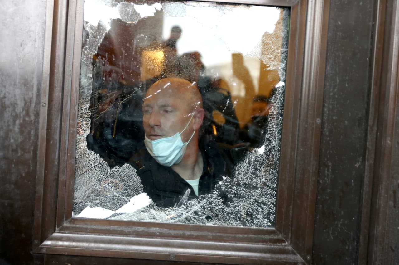 Un oficial de la Policía del Capitolio frente a una de las puertas golpeadas por la turba.