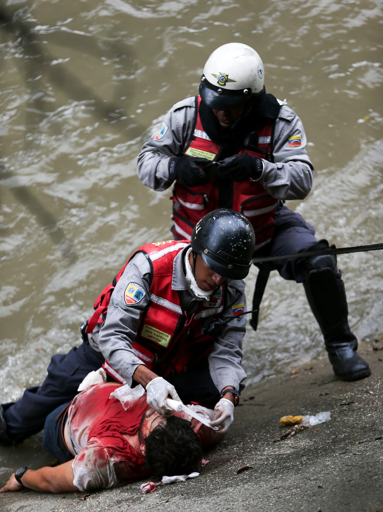 Rescatistas atienden a una de las personas que cayó en el río Guaire después de ser herido por un cartucho de gas lacrimógeno disparado por la Guardia Nacional Bolivariana.