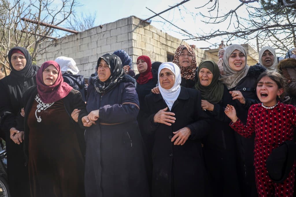 Familiares y vecinos lloran durante la procesión fúnebre por cuatro miembros de las fuerzas de seguridad sirias muertos en enfrentamientos con leales al derrocado presidente Bashar Assad en la costa de Siria, en la aldea de Al-Janoudiya, al oeste de Idlib, el sábado 8 de marzo de 2025.