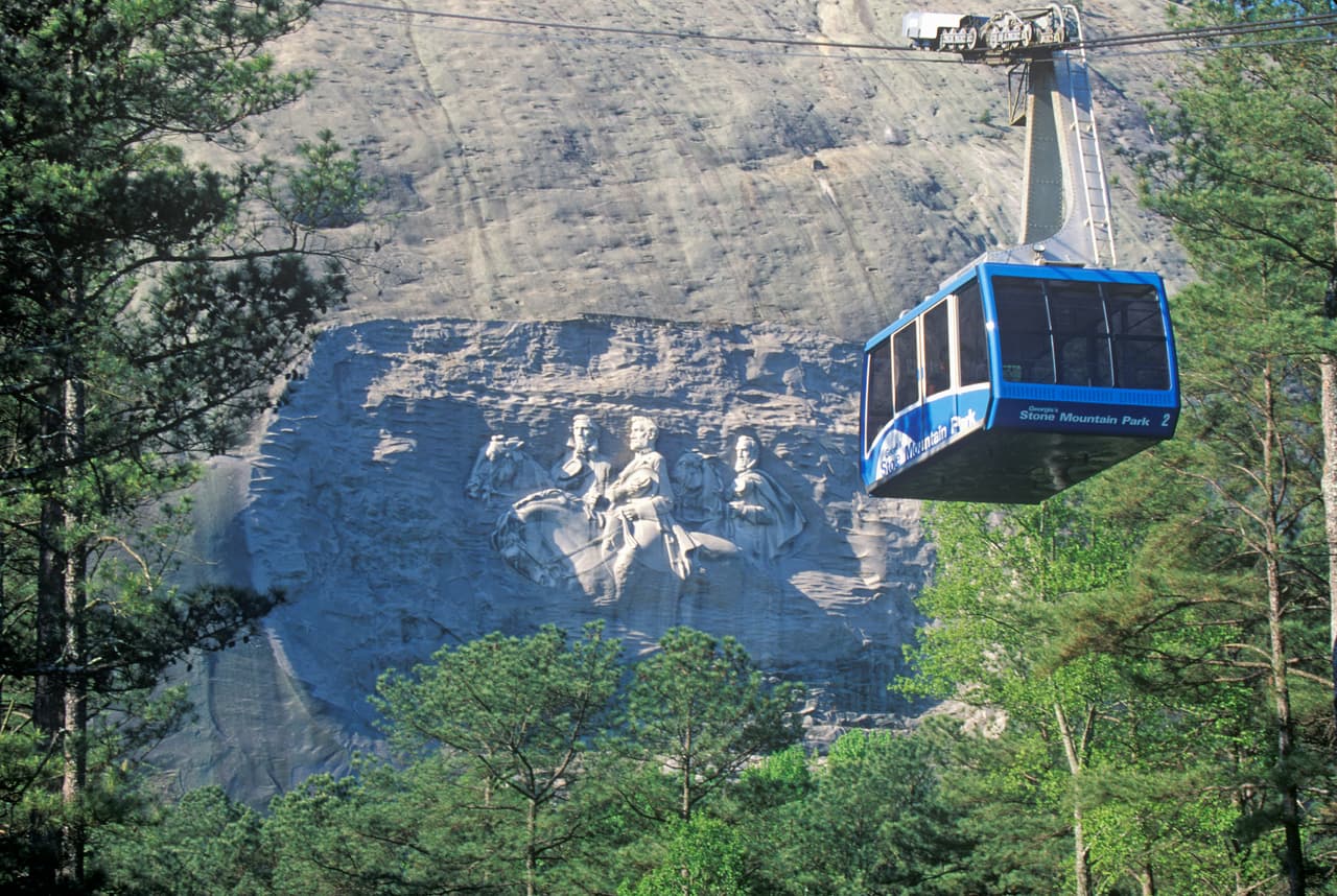 La cumbre de la montaña está a 1,686 pies de altura y se puede alcanzar con un pequeño teleférico . La talla de los tres hombres está a 400 pies del suelo y mide 158 pies de largo por 76 de ancho.