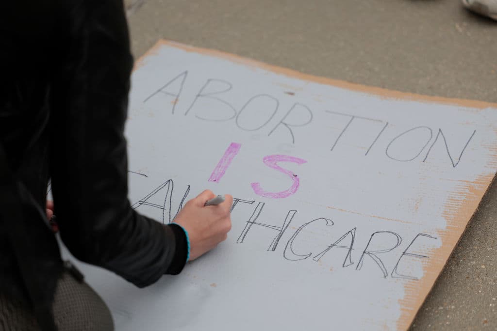 "El aborto es sanidad", se lee en un cartel que es preparado por una asistente a la manifestación llevada a cabo frente a la Corte Suprema. Este martes el jefe de la 
<a href="https://www.univision.com/temas/corte-suprema">Corte Suprema</a>, el magistrado John Roberts, confirmó "la autenticidad del borrador de opinión" revelado por Politico.