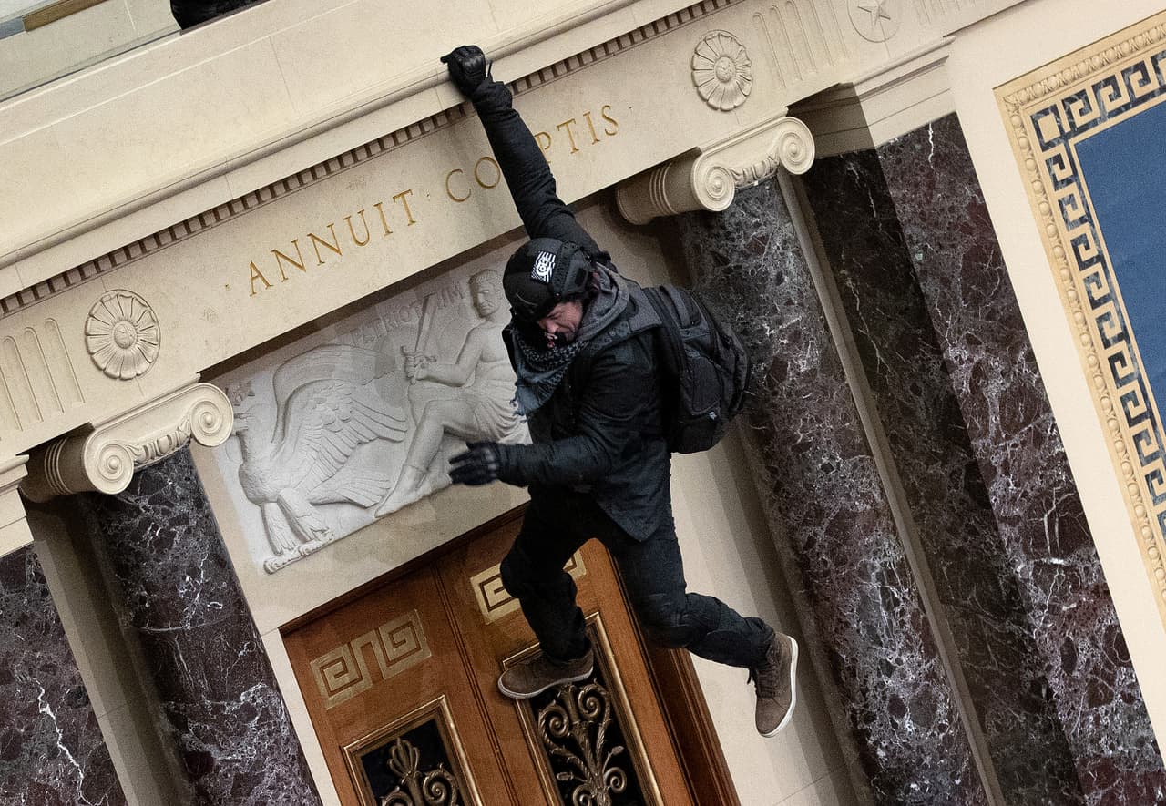 <b>El asaltante araña</b>
<br>
<br>Varios sujetos con sofisticados equipos de asalto, cascos, chalecos antibalas y otros objetos, entraron a la Cámara del Senado. Uno de ellos fue fotografiado mientras se sostenía en la pared para bajar desde el balcón de la sala al área principal.
<br>