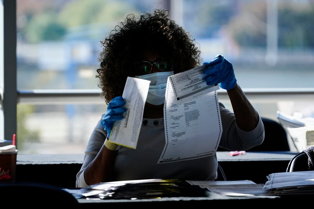 Una trabajadora electoral examina un voto en un centro de Atlanta, Georgia, un estado donde el margen a favor de Trump se ha ido reduciendo con el paso de las horas. 
<br>