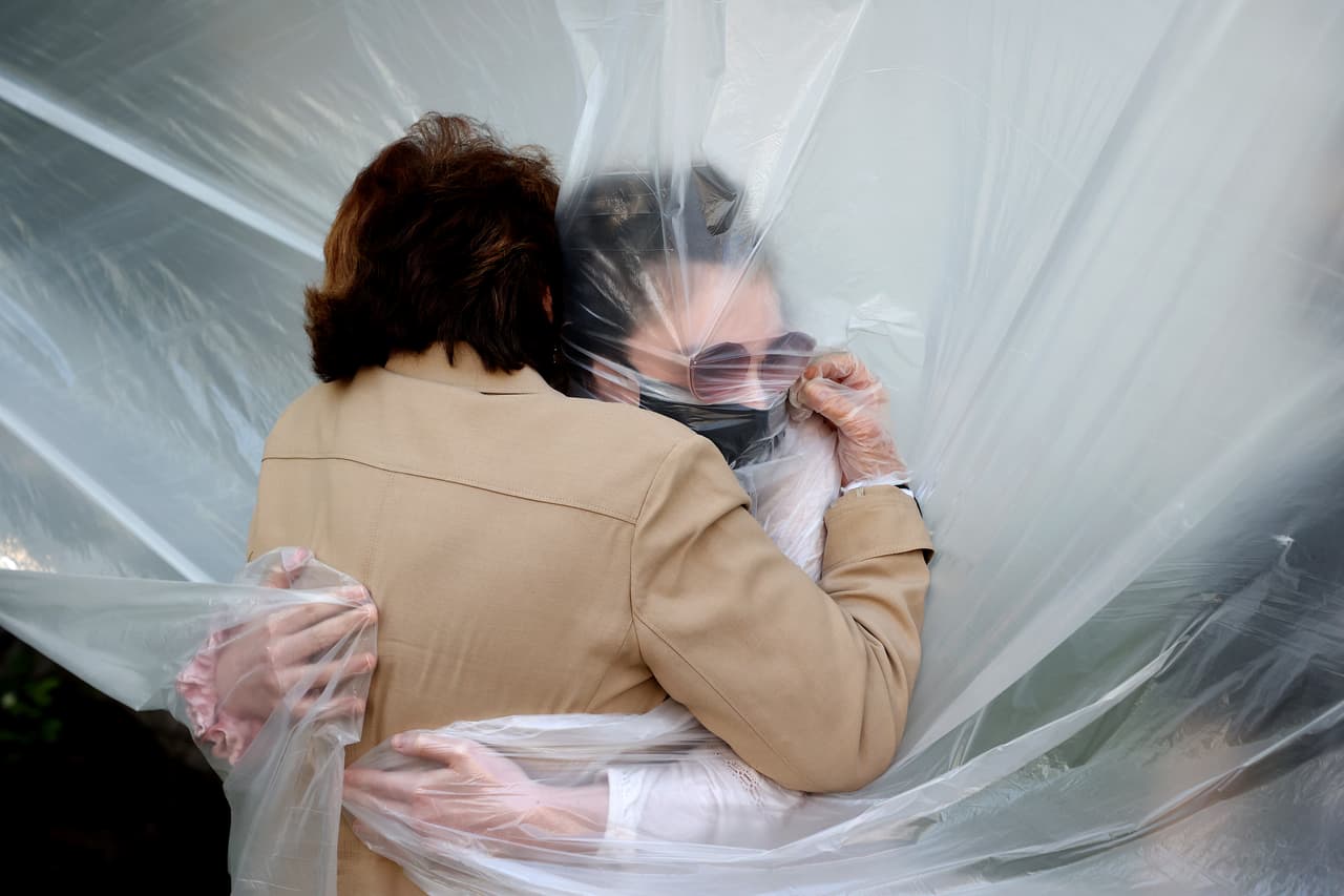 <b>Un abrazo seguro (24 de mayo): </b>Olivia Grant (a la derecha) abraza a su abuela, Mary Grace Sileo, a través de una tela plástica colgada en un tendedero en Wantagh, Nueva York. Se veían por primera vez desde que comenzó la pandemia.