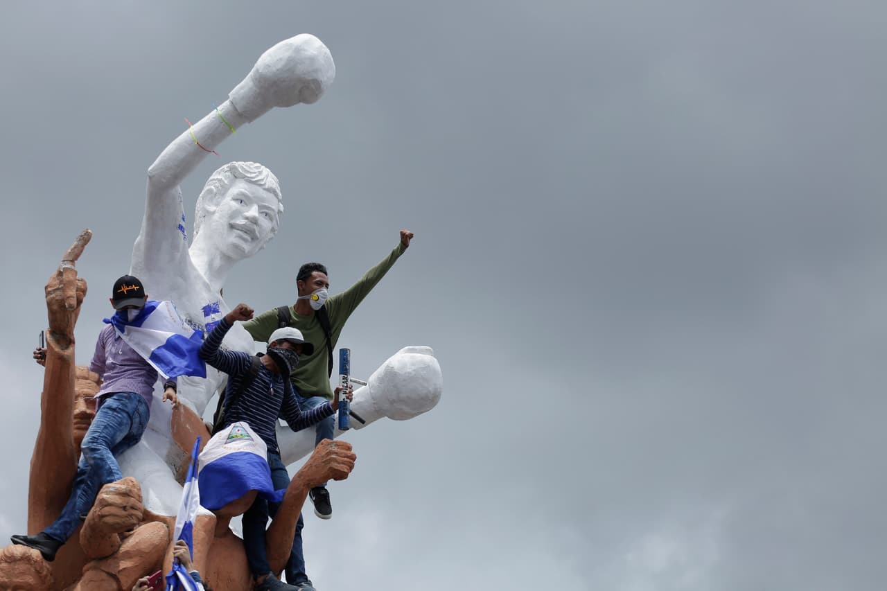 Cientos de personas participaron este jueves en una multitudinaria marcha en diversas ciudades de Nicaragua. Con el lema "Juntos somos un volcán" los ciudadanos rechazaron la represión que ya ha dejado más de 300 muertos y pidieron la salida del presidente Daniel Ortega. En la imagen, un grupo de jóvenes con banderas de Nicaragua en la estatua del campeón mundial de boxeo y ex alcalde de Managua Alexis Argüello.