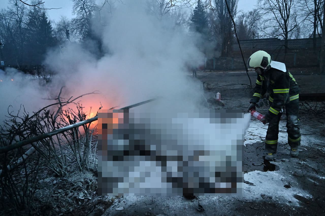 Un bombero extingue el fuego de los cuerpos de personas que fueron alcanzadas por el ataque ruso a la principal torre de televisión de Kiev, el 1 de marzo. 
<br>