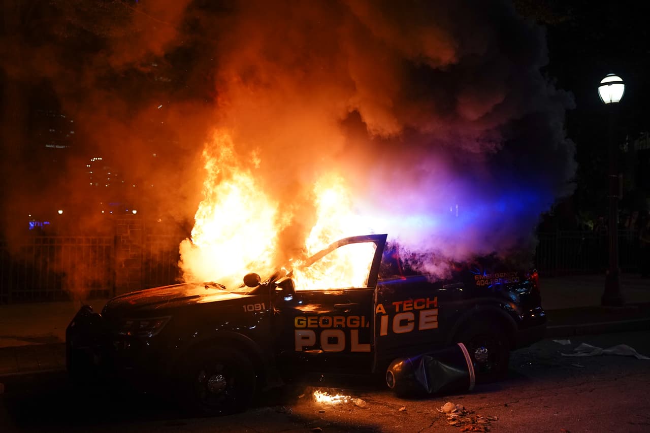 Un auto de la policía se quema durante una protesta el 29 de mayo de 2020 en Atlanta, Georgia.