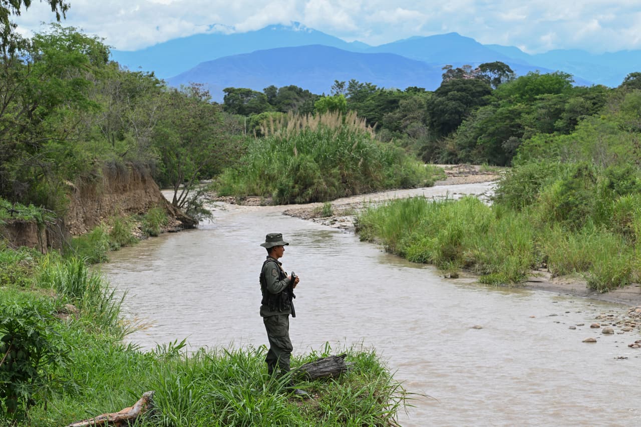 Un soldado de la Fuerza Armada Nacional Bolivariana de Venezuela hace guardia a orillas del río Táchira. 
<b>Los dos países vecinos también reactivarán la conectividad aérea comercial. La aerolínea venezolana Turpial Airlines, proveniente de Caracas, será la primera en aterrizar el lunes en Bogotá.</b> Se trata de un cambio en el plan inicial en el que se anunció que el primer vuelo lo haría el Consorcio Venezolano de Industrias Aeronáuticas y Servicios Aéreos (Conviasa).
<br>
<br>