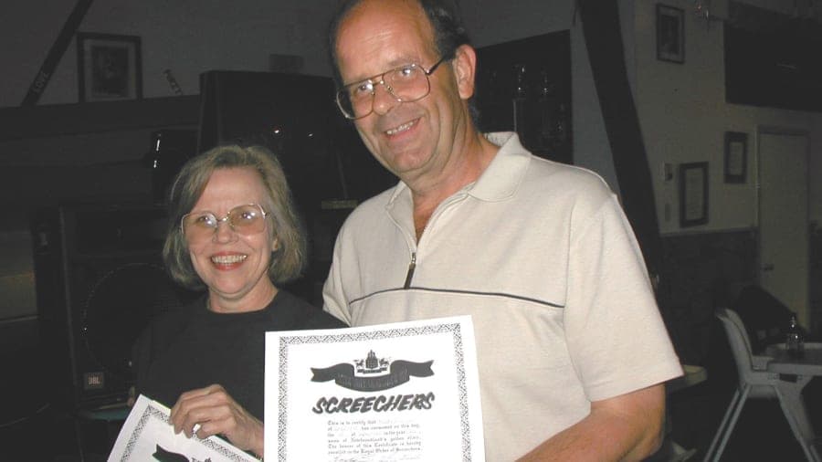 Diane Kirschke y Nick Marson con el certificado de haber participado en el ‘Screech-In’, que incluye beber una bebida llamada Screech (con sabor a ron) y besar a un ejemplar de bacalao.