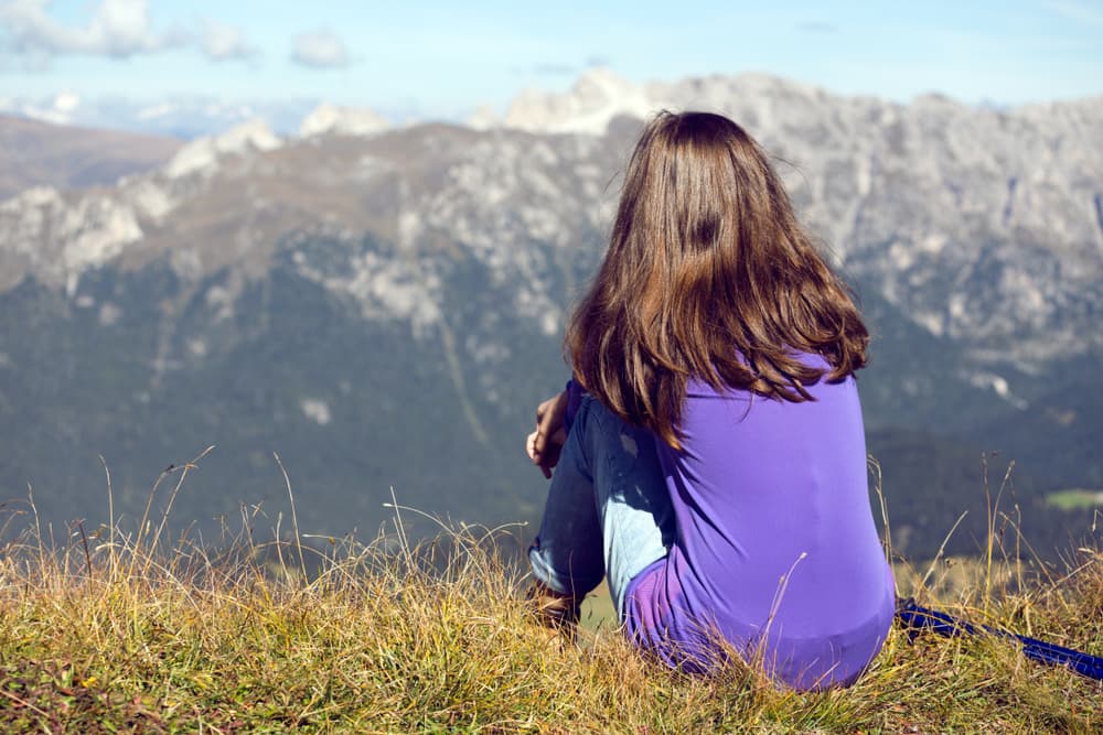 Mujer joven de espaldas mirando el paisaje