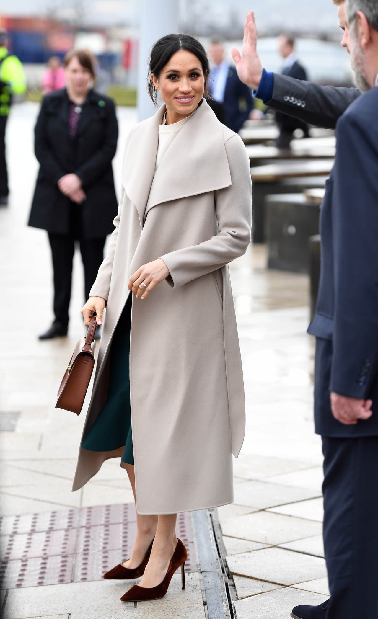 <b>23 de marzo, 2018</b>
<br>En su primer viaje a Belfast, Meghan volvió a dar lecciones de estilo. Eligió un abrigo color arena de Mackage con zapatos de terciopelo color óxido Altazzura y un bolso de asa corta de Bloomsbury.