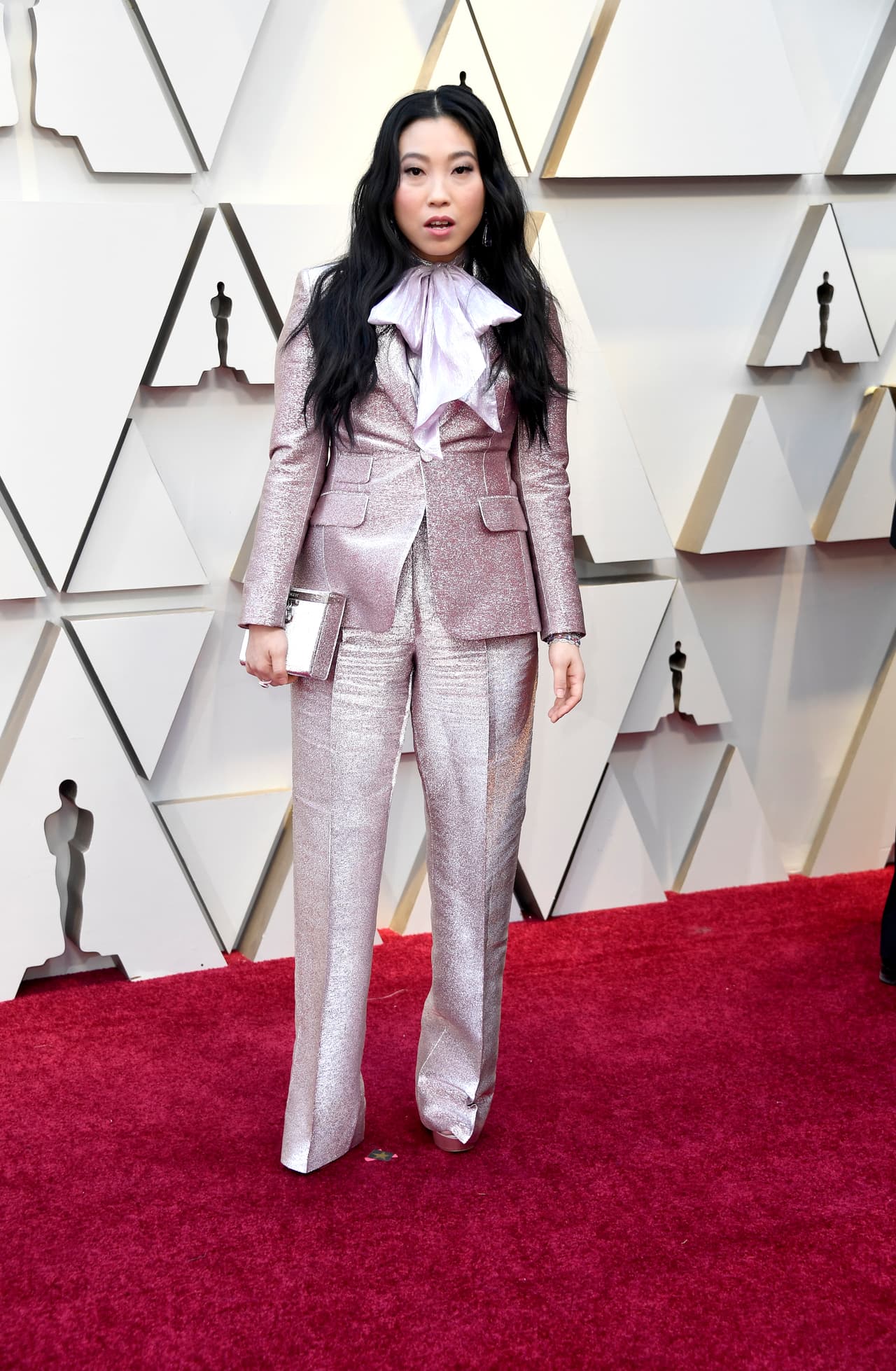 La actriz Awkwafina de 'Crazy Rich Asians' brilló sobre el resto con un espectacular traje de pantalón metálico con blusa de lazo al cuello en color lavanda.