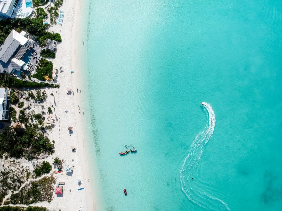 <b>Puesto 5:</b> 
<b>Playa de Grace Bay (Providenciales, Turcos y Caicos)</b> 
<br>
<br>“Es un entorno absolutamente idílico”, reseñó uno de los visitantes de este paraíso en el mar Caribe al 
<a href="https://www.univision.com/noticias/mundo/playas-mas-hermosas-mejores-del-mundo-2022-trip-advisor-fotos" target="_blank">ser en 2022 la mejor playa del mundo</a>. “Su arena dorada está bordeada de agua azul cristalina, un paisaje digno de una postal”, agregó.