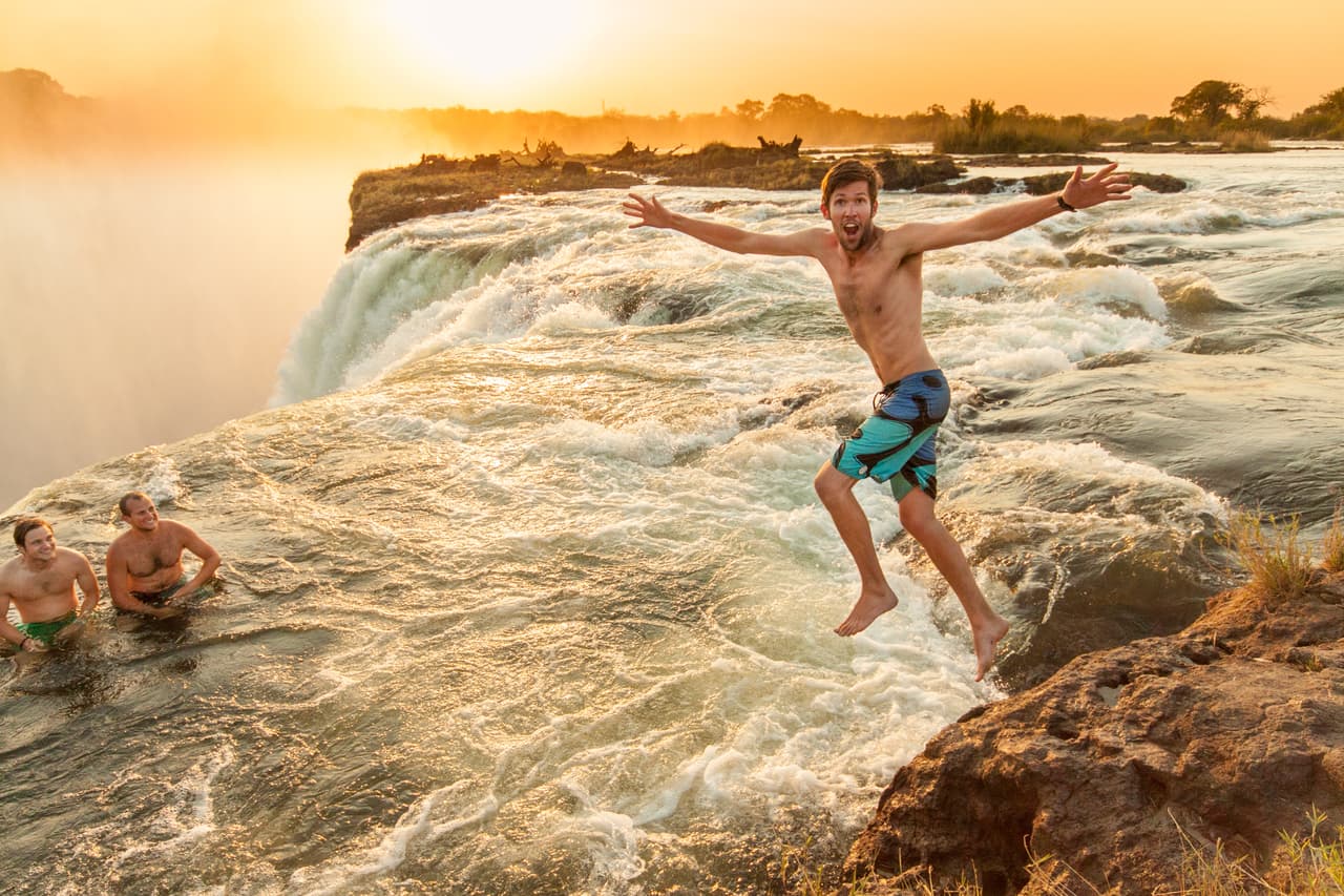 <b>Diciembre. La piscina del diablo, Cascadas Victoria, Zambia.</b>
<br>
<br>Por sí sola las Cataratas Victoria se podrían calificar como uno de los fenómenos naturales más hermosos del mundo. Aproximadamente una milla de ancho con una caída de 360 pies, es la cortina de agua más grande del planeta. 
<br>
<br>Pero lo que tiene en su cima es aún más inusual: un hoyo natural en el borde de la caída de agua con una barrera de roca 
<a href="https://www.zambiatourism.com/"><u>que permite nadar con seguridad hasta el borde de la cascada</u></a>.