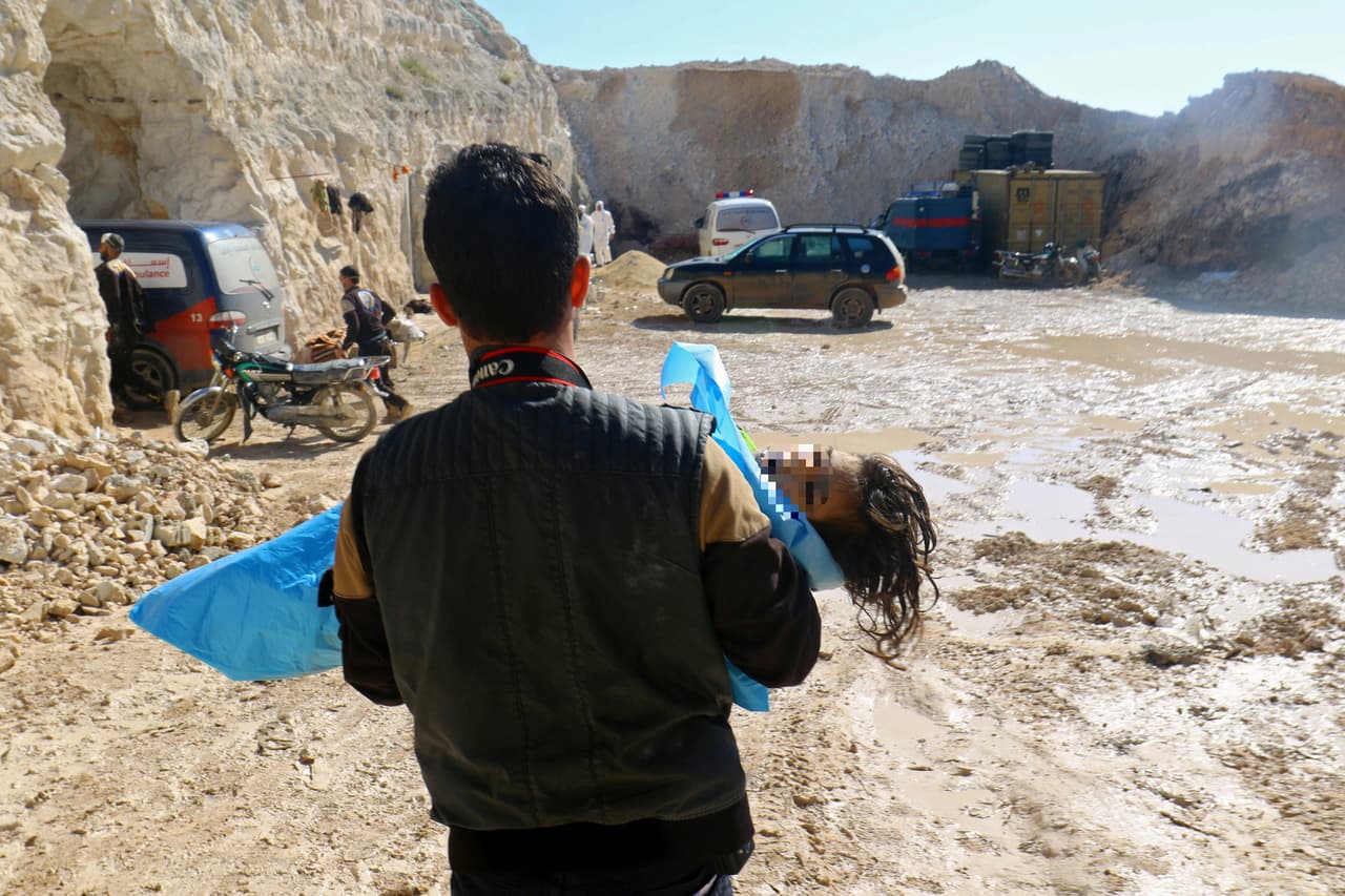 Un rescatista lleva el cuerpo de un niño que murió a consecuencia de la exposición a elementos químicos en Siria