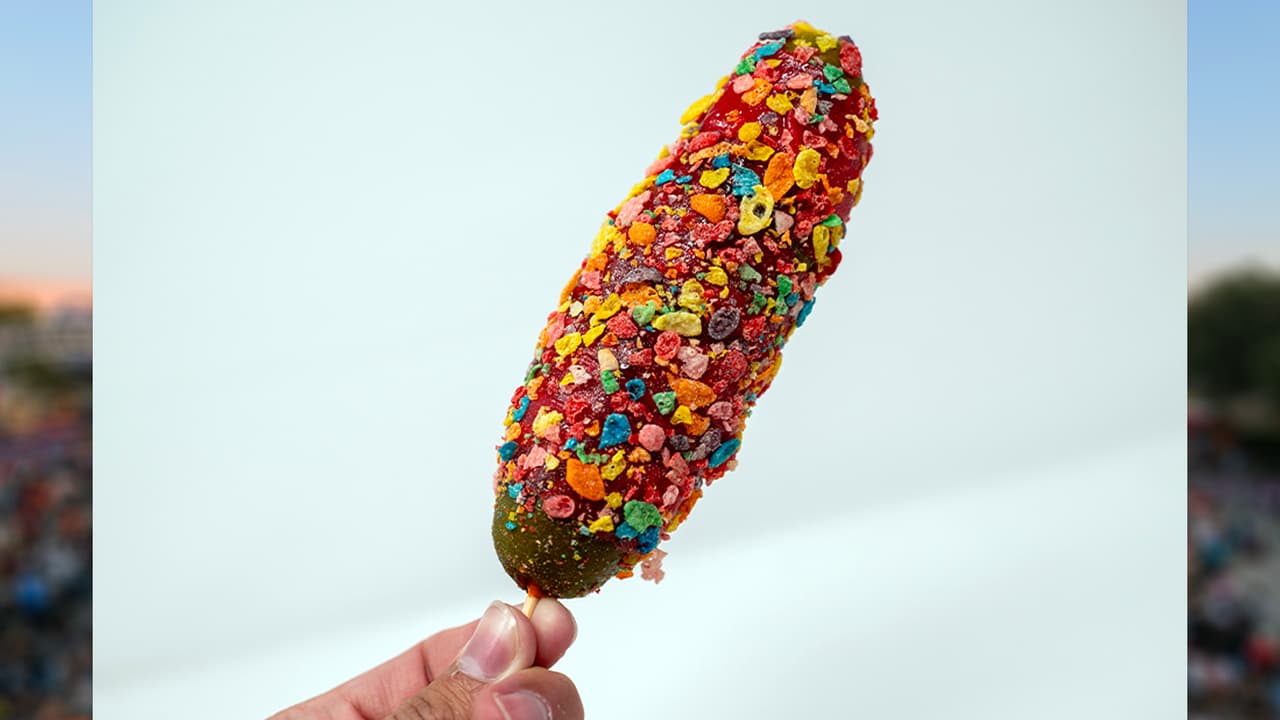 <b>THE FRUITY PEBBLE PICKLE</b> de Candy Pickle Factory 
<br>
<b>Un delicioso pepinillo envuelto con Fruit Roll-Up</b>, rociado con sirope de azúcar y recubierto con cereales, además, con un toque de sirope de helado de fresa. 
<b>Es crujiente, dulce y delicioso</b>.