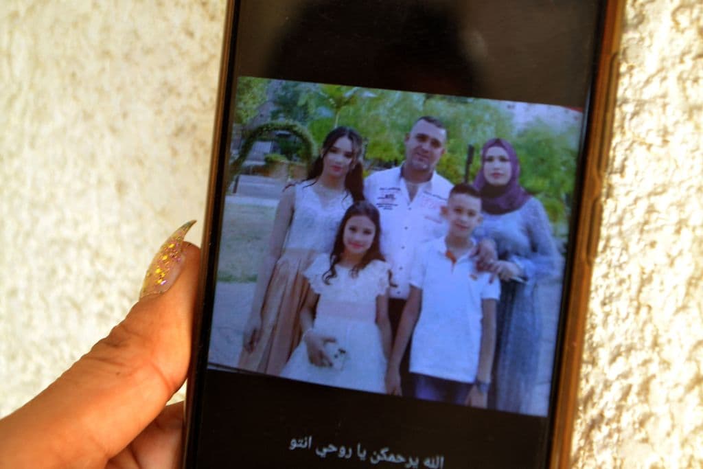 Una mujer en la ciudad libanesa de Trípoli muestra una foto de sus familiares que fallecieron en el naufragio.