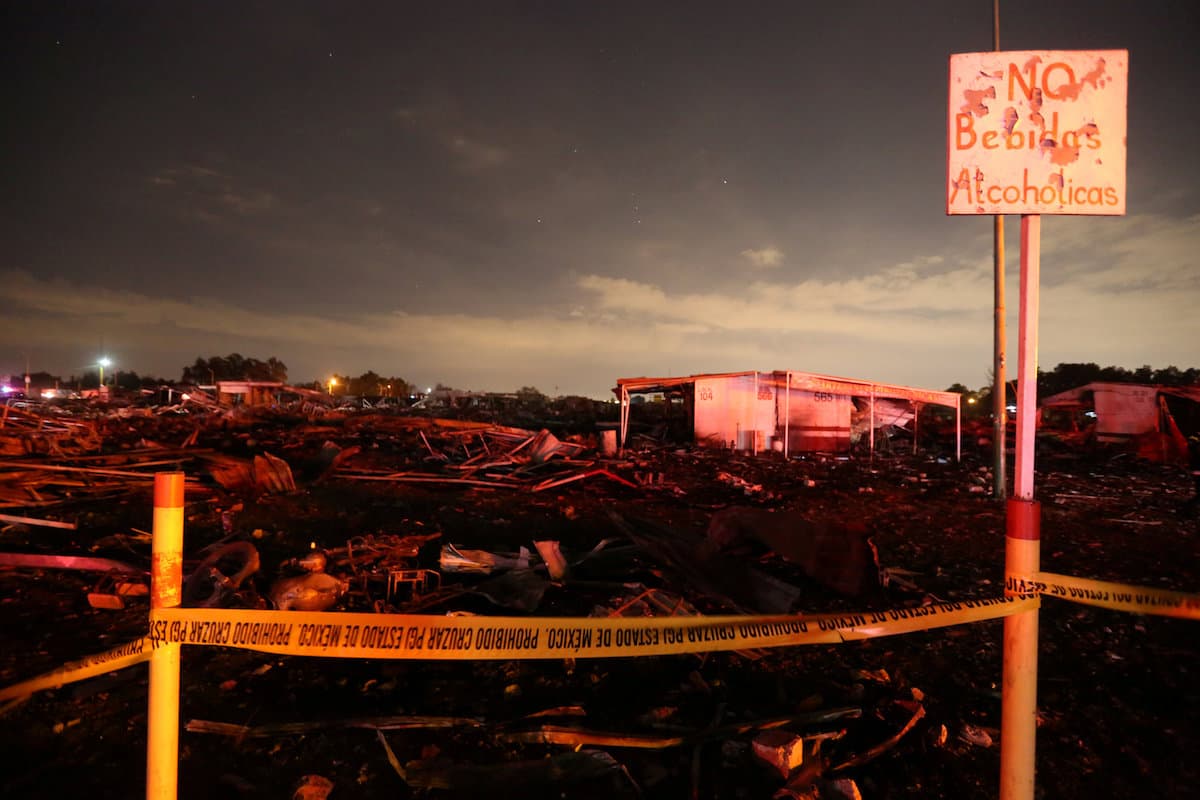 El pie del letrero de "No bebidas alcohólicas" sostiene el precinto del área donde ocurrió la explosión y el incendio