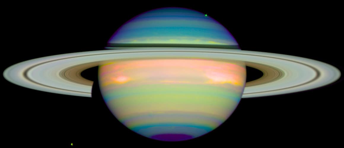 <b>Saturno infrarrojo (1998). </b>Esta imagen tomada el 4 de enero de 1998 muestra la luz infrarroja reflejada del planeta. Los colores azules indican una atmósfera clara. Los colores verde y amarillo indican una neblina sobre la capa de nubes principal. Los colores rojo y naranja indican nubes que alcanzan la atmósfera. Los anillos formados por trozos de hielo lucen blancos.