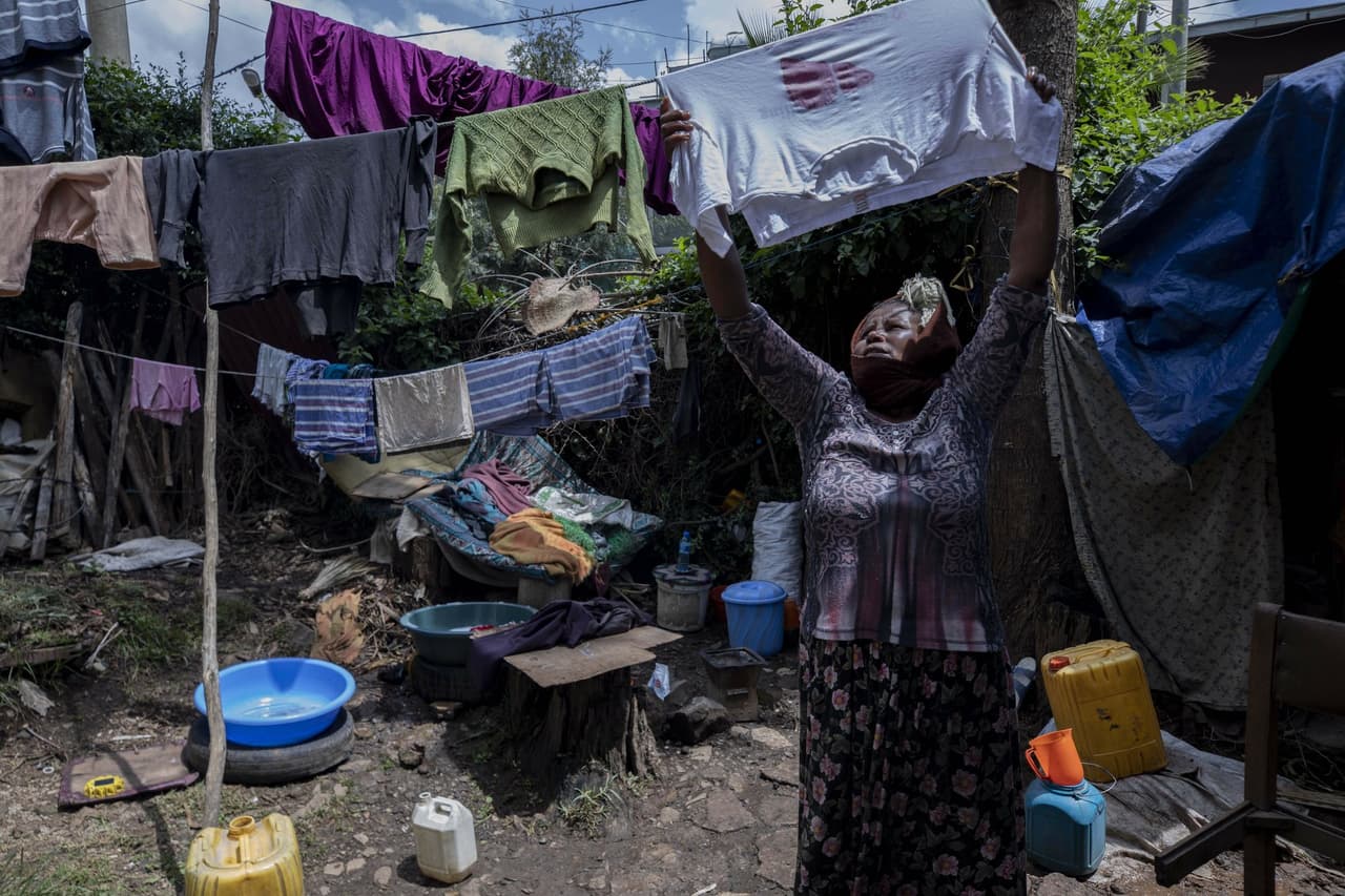 Madre de dos hijos, Amsale Hailemariam, una trabajadora doméstica que perdió el trabajo debido al coronavirus, cuelga ropa después de lavarla fuera de su pequeña tienda en la capital Addis Abeba, Etiopía.