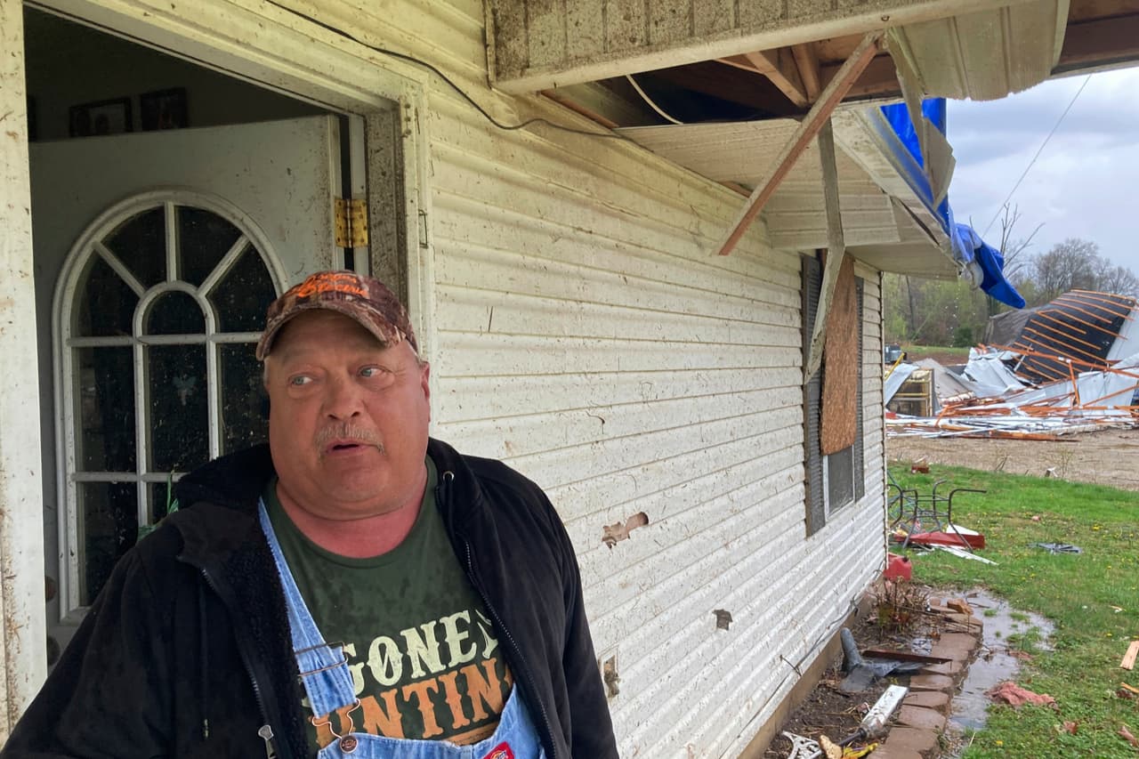 Keith Lincoln, un hombre de 56 años que reside en Glen Allen, Missouri, fue despertado por una alerta telefónica. Segun contó a la agencia AP, el hombre se refugió en una bañera con su esposa y su hija de 18 años y rezó: “Solo sálvanos a nosotros y a la casa”. Pasó la tarde reparando su techo, pero estaba agradecido de que su oración fuera respondida, en su mayoría. En la fotografía, el hombre aparece este miércoles frente a la puerta de su vivienda.