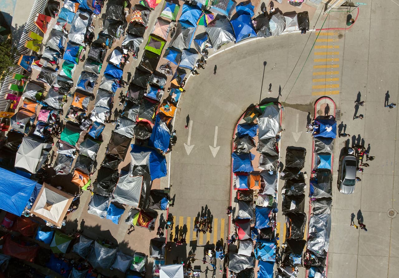 <b>Campo de migrantes en Tijuana</b>
<br>
<br>Vista aérea de un campamento de migrantes que alberga a solicitantes de asilo en Estados Unidos, frente al cruce de El Chaparral en Tijuana, México, el 17 de marzo.
<br>
<br>Hasta allí han llegado decenas de migrantes que huyen de la pobreza y violencia en Centroamérica. Debido a un programa instaurado por la administración de Donald Trump y que una corte determinó continúe bajo la de Joe Biden, los Protocolos de Protección del Migrante (MPP), han tenido que esperar en esa zona la resolución de sus casos de asilo en Estados Unidos.